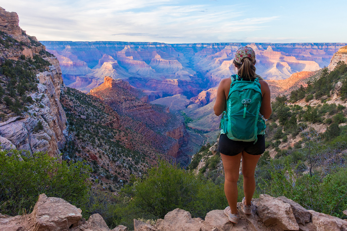 A solo hiker facing the vastness of the Grand Canyon.
