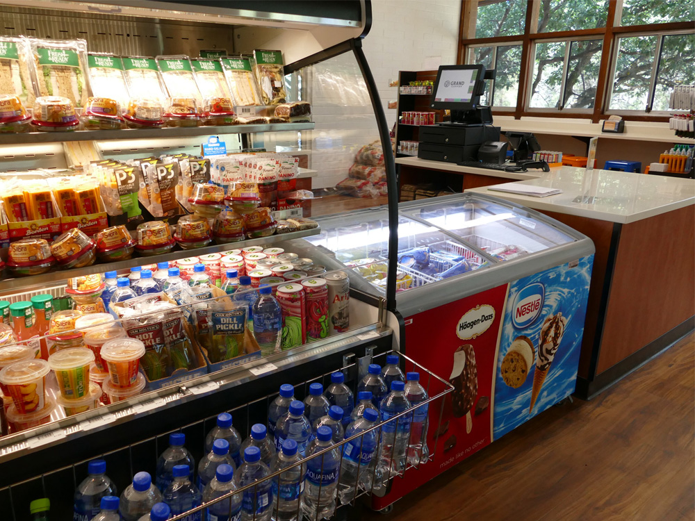 Food displayed in an open convenience-store fridge next to a Hagen Daz and Nestle freezer unit.