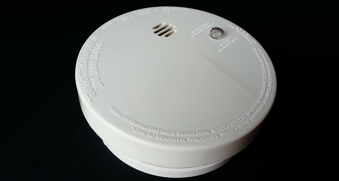 A smoke alarm in front of a white background.