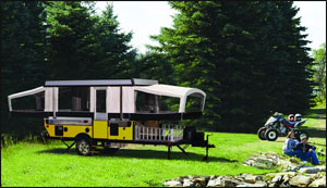 Couple camping in pop-up trailer with ATVs