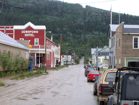 Dawson City small town with evergreen trees on mountain