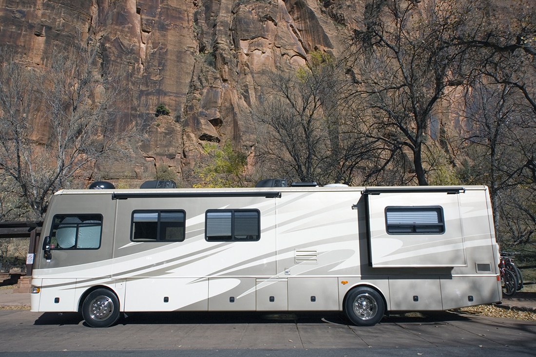 RV parked against a cliff wall.