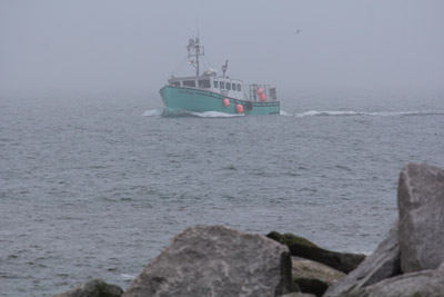 The incoming tide brings with it fog, but also means lobster boats can return to the harbor.