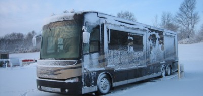 Large brown and tan RV in snowy weather