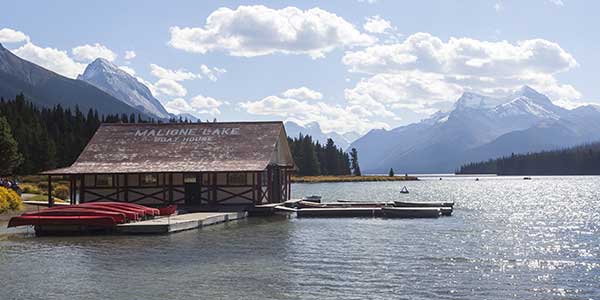 A dock with a house and kayaks.