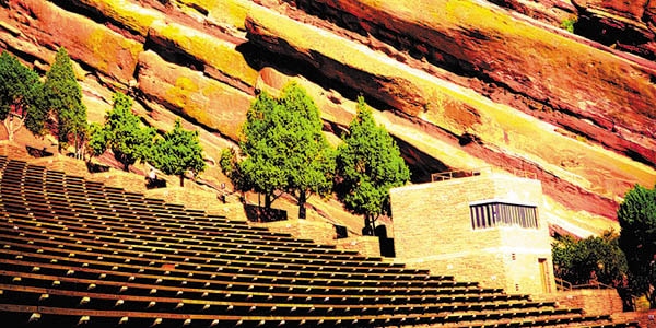 Rows of seats build into the natural slope of a rocky slope, forming an amphitheater.