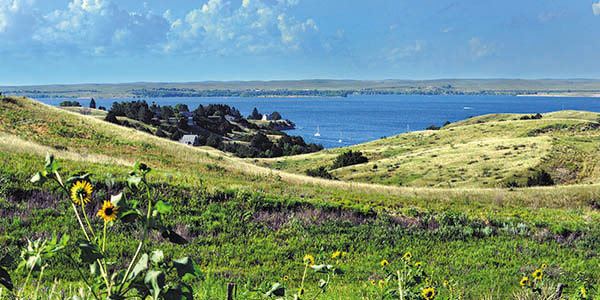 Looking over rolling hills in the foreground to a blue lake in the background.