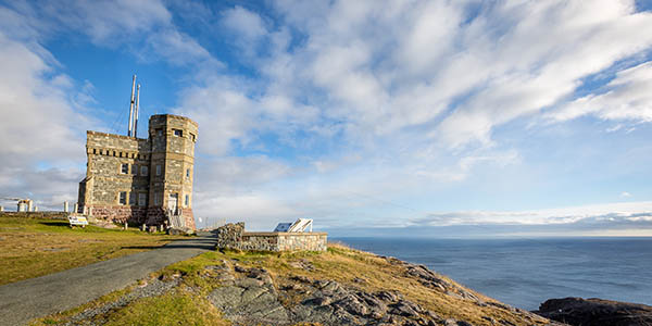 A castle-like structure overlooks a wide stretch of ocean.