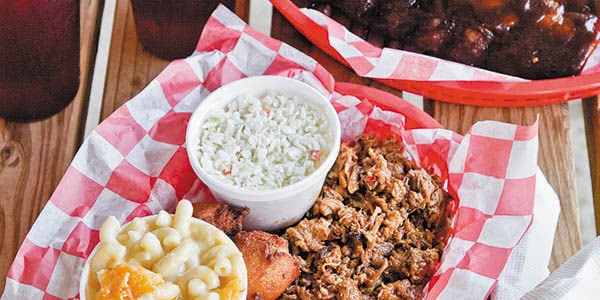 A seafood dish with sides of slaw and macaroni