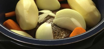 Onions, potatoes and carrots cooking in pressure cooker