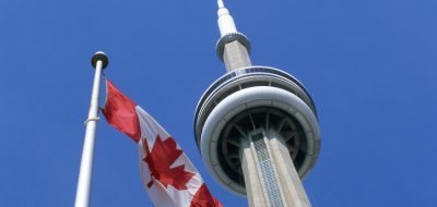 CN Tower in Toronto Canada with Canadian flag waving