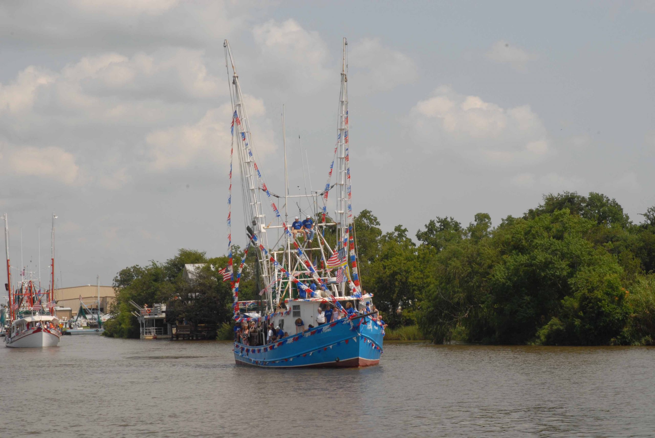 Blue shrimp boat with colorful flags on mast in Iberia Parish, Louisiana