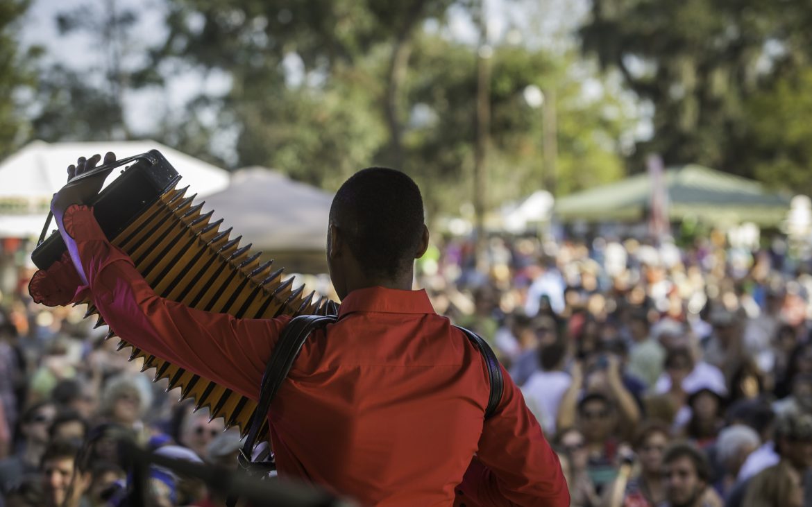 Young African American man playing accordion on stage in New Orleans