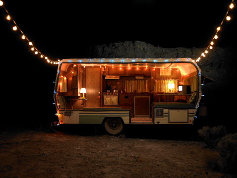 Travel trailer decorated in holiday lights at night