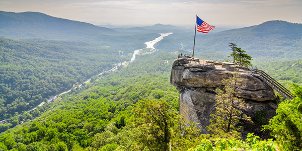 An American flag over a rock promontory