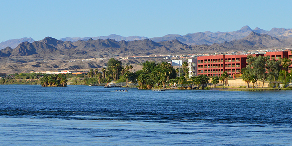 Colorado River rolling past hotels and mountains.