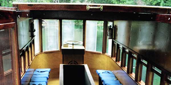 A glass-bottomed boat with seats on both sides.