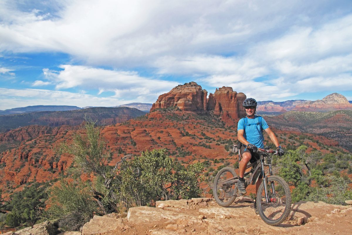 Man with mountain bike over rugged desert landscape. 