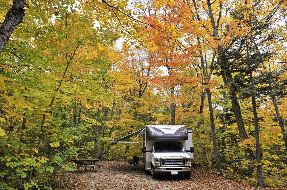 Motorhome parked near fall colored trees