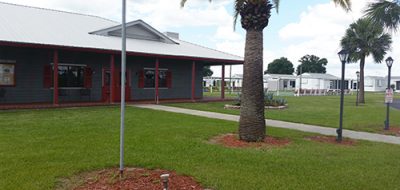 Little Willies RV Resort building and grassy area with palm trees