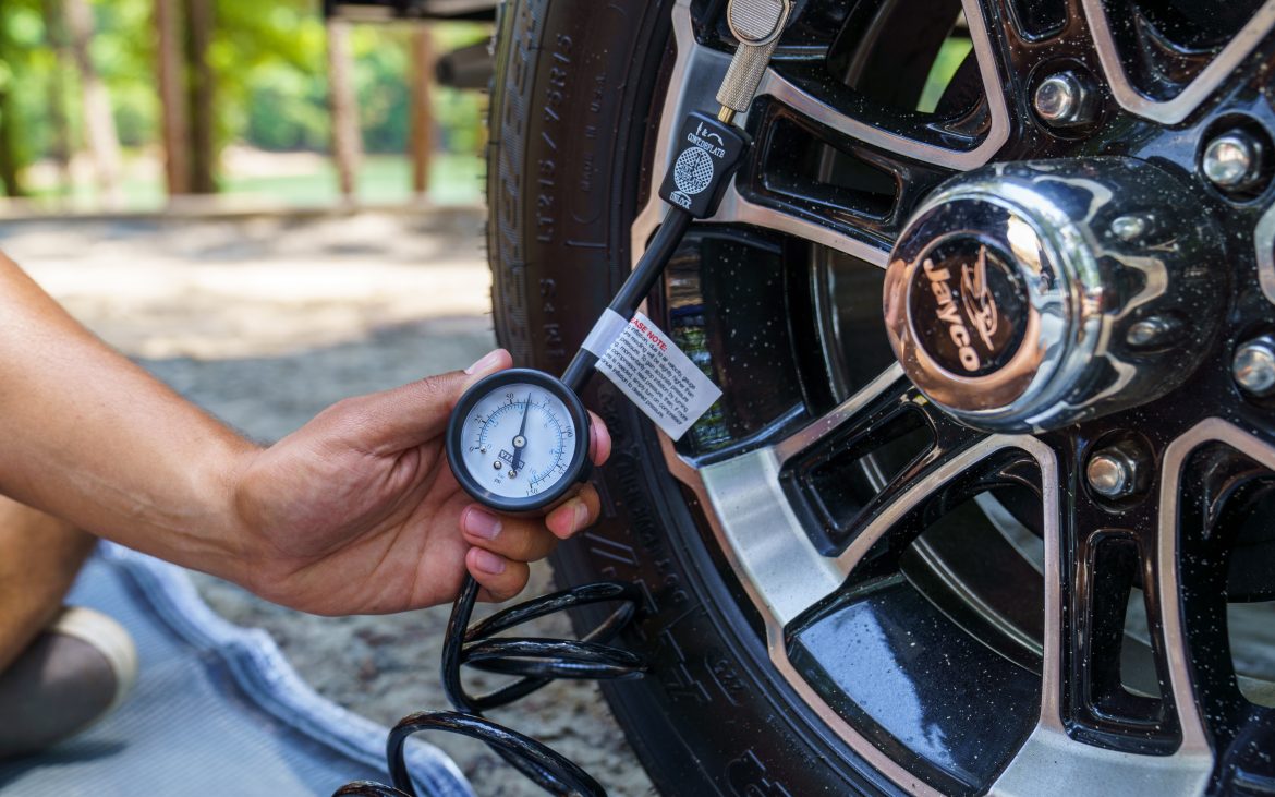 Using a gauge to measure the pressure in an RV tire. 