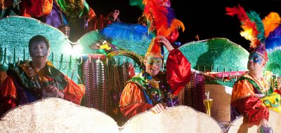 Dancers and performers wearing Mardi Gras colorful clothes