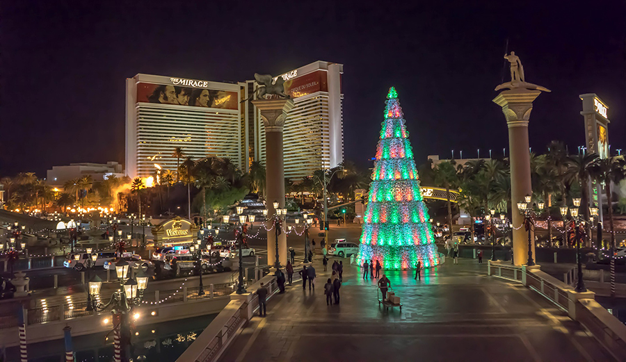 Christmas tree lit up with The Mirage building in background at night