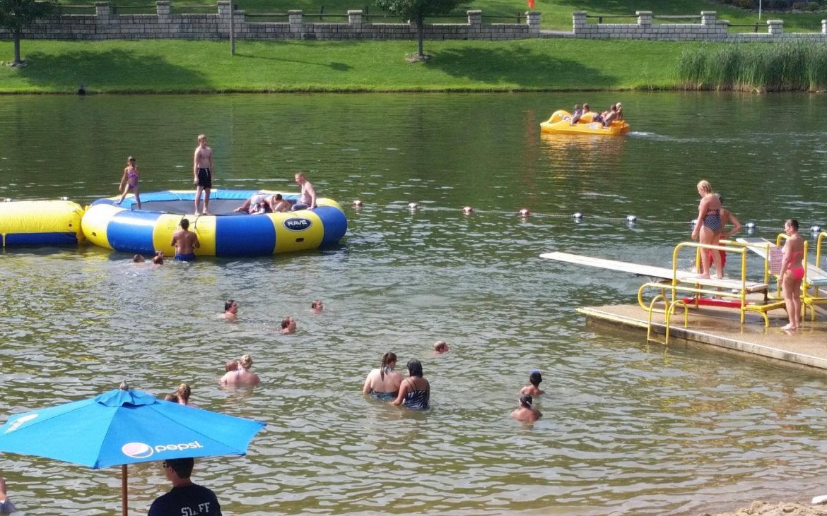 Many people, families, and kids playing in the lake at Wood's Tall Timber Resort