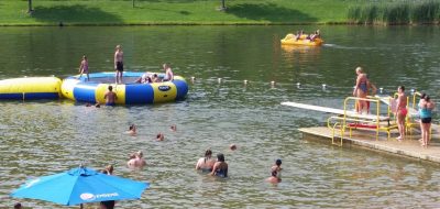 Many people, families, and kids playing in the lake at Wood's Tall Timber Resort