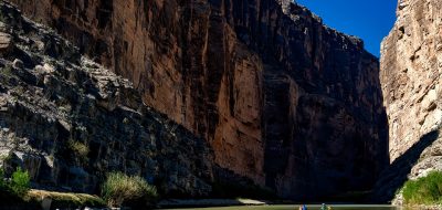 Canoeing in the Rio Grande River under huge cliffs