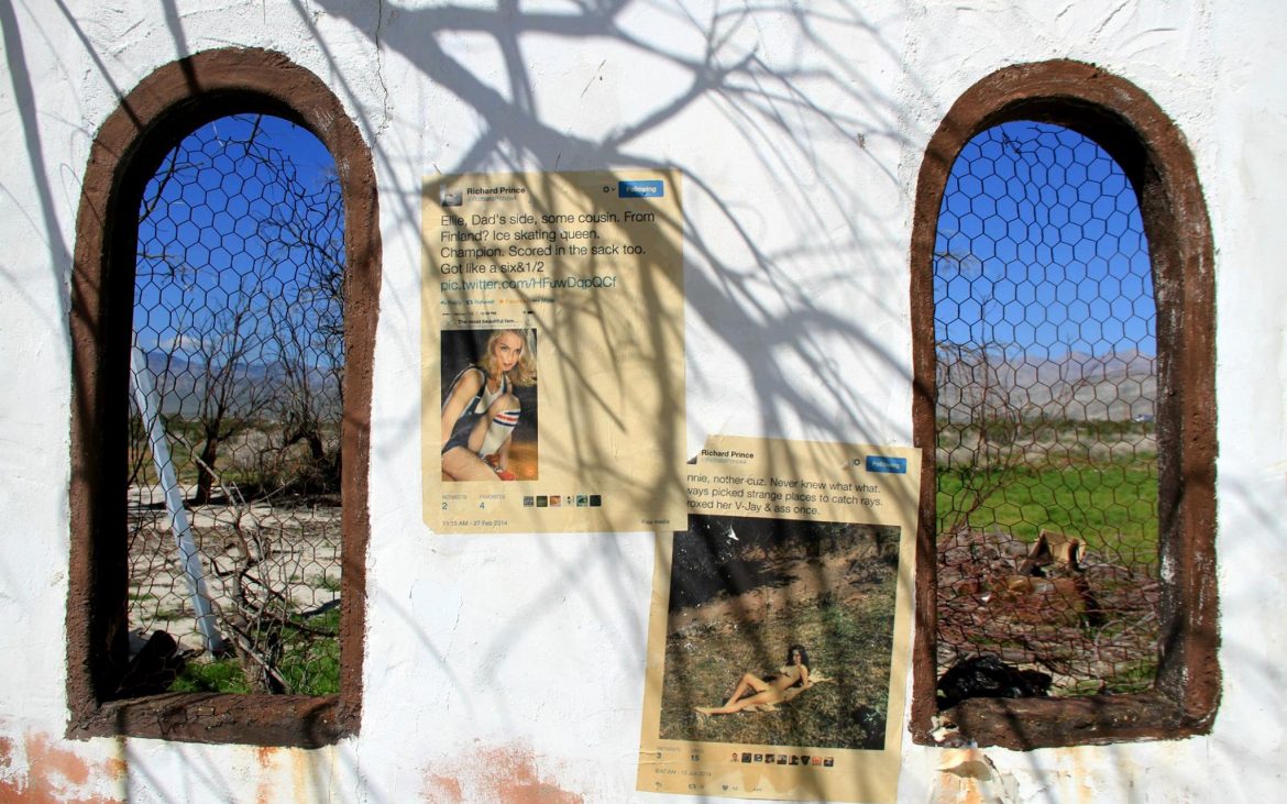 Taped tweets on abandoned white building with tree shadow