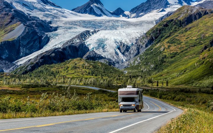An RV travels along the Richardson Highway in Alaska. In the background is Worthington Glacier.
