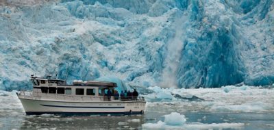 Tour boat in front of large glacier