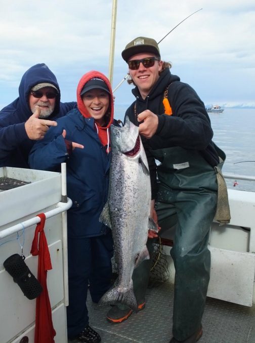 Group holding up a caught fish on the ocean