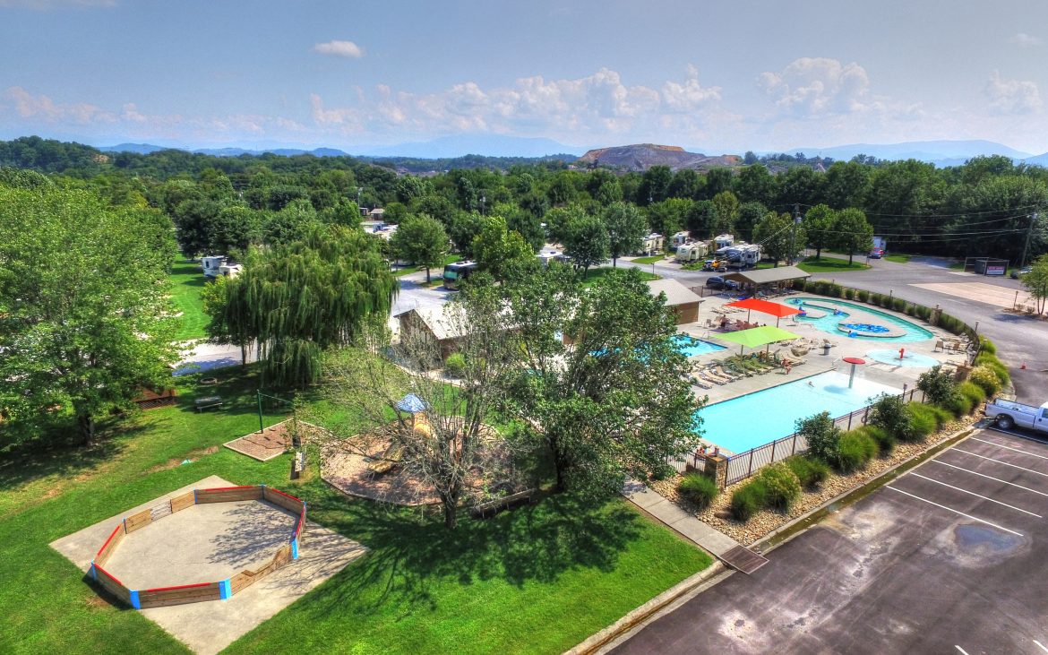 Aerial view of bright and clean community pool surrounded by lush trees