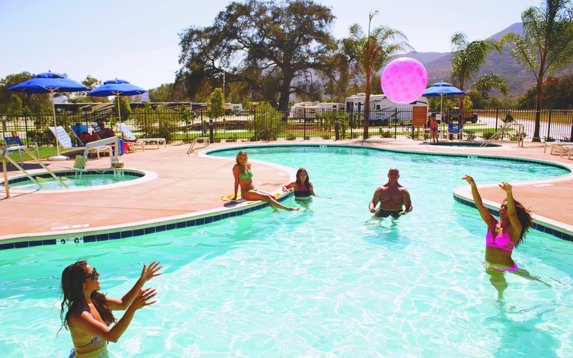 People playing in crystal clear community pool