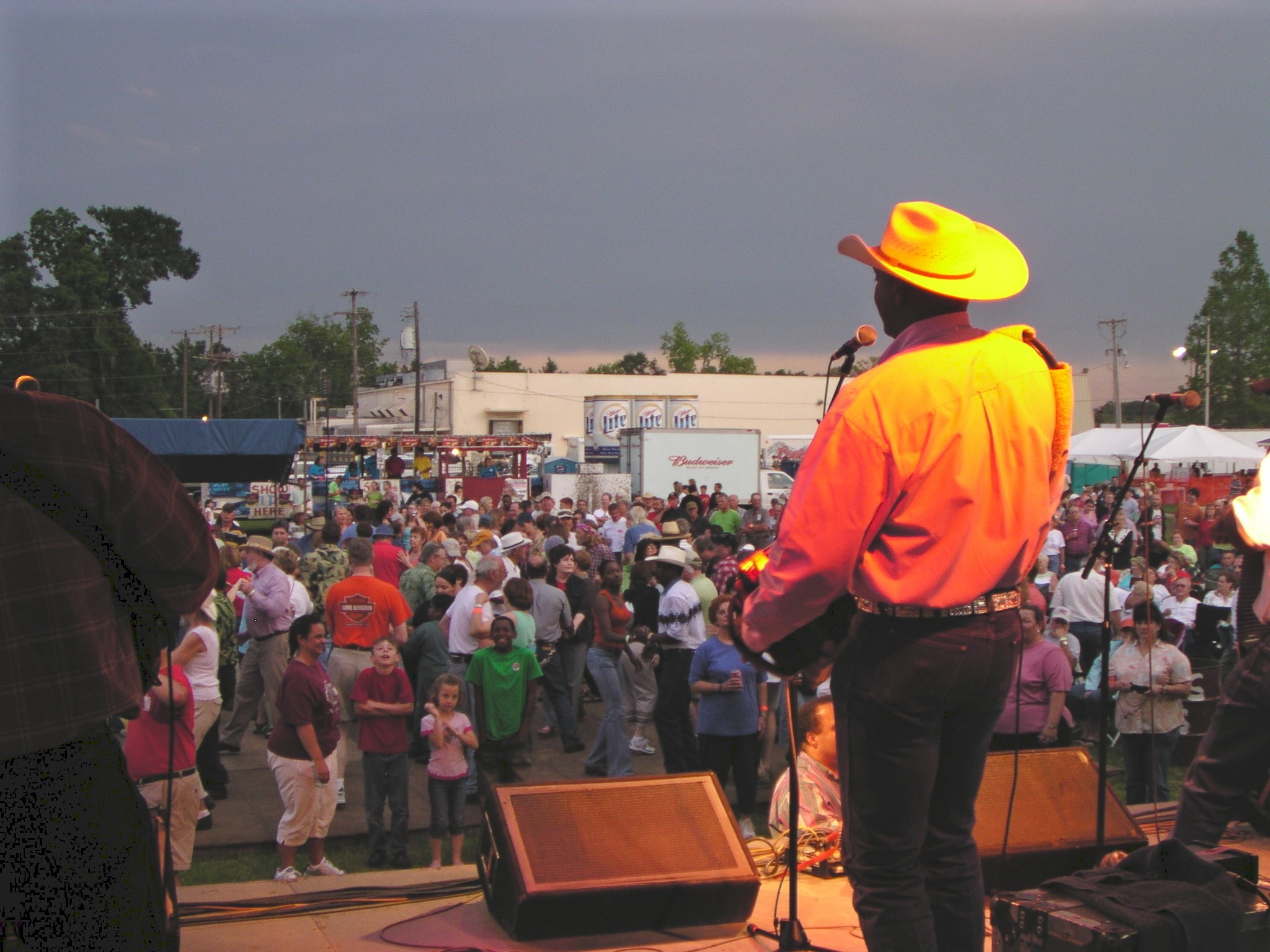 Man in yellow shirt and hat addressing a crowd