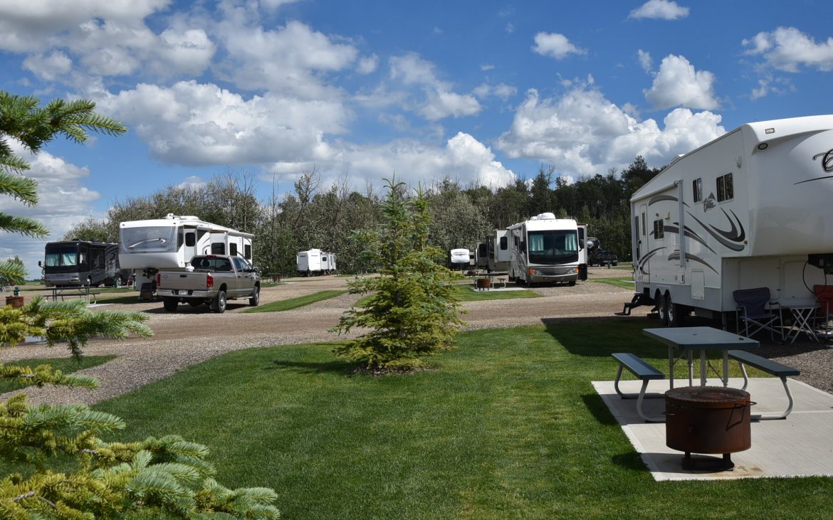 Many RVs and Trailers along landscaped greens
