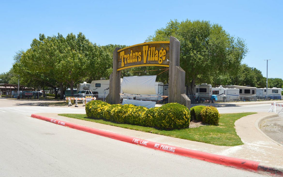 Brown and yellow wooden Traders Village entrance sign