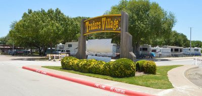 Brown and yellow wooden Traders Village entrance sign