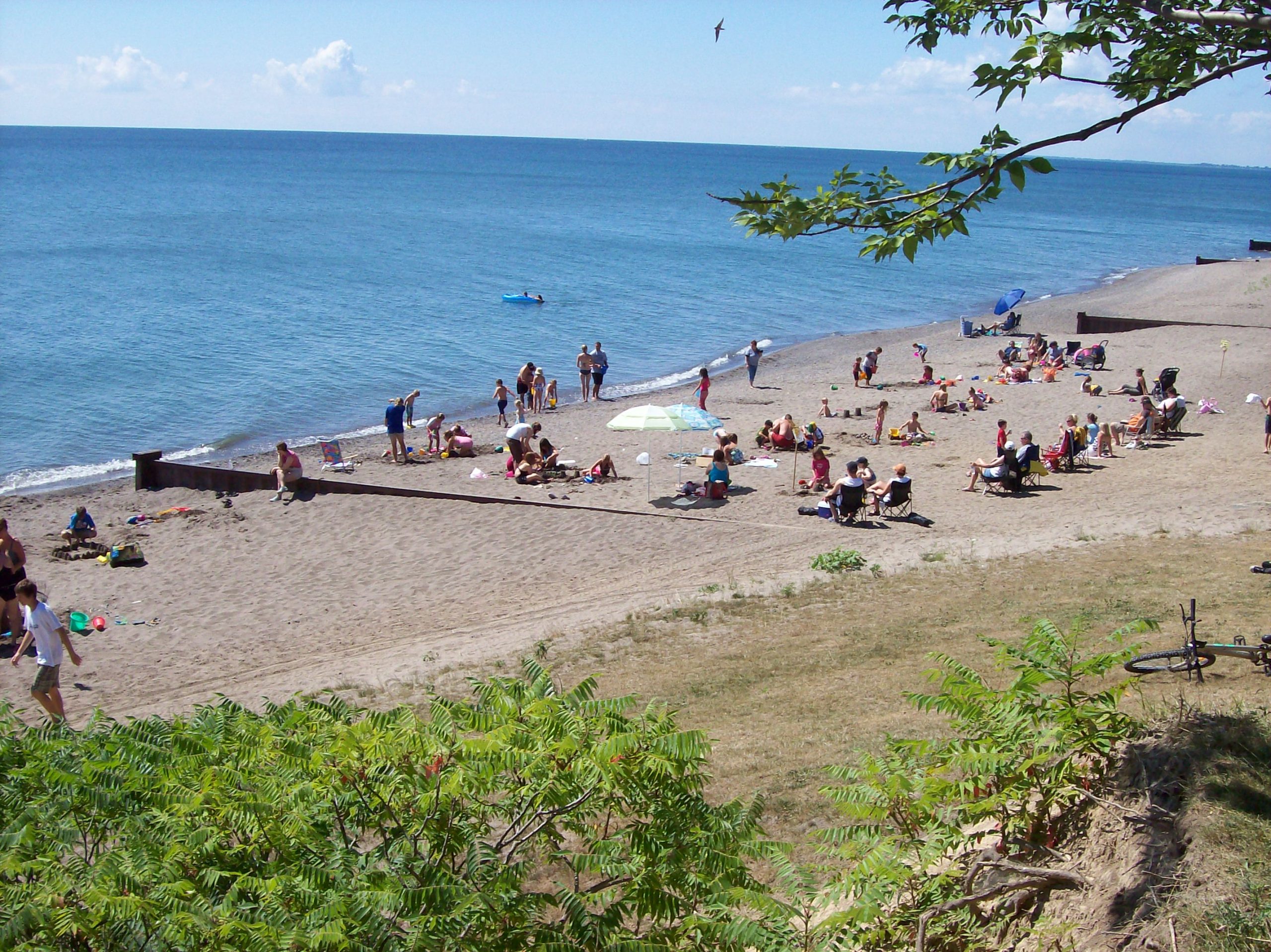 Dozens of campers relaxing and playing on the sandy beach