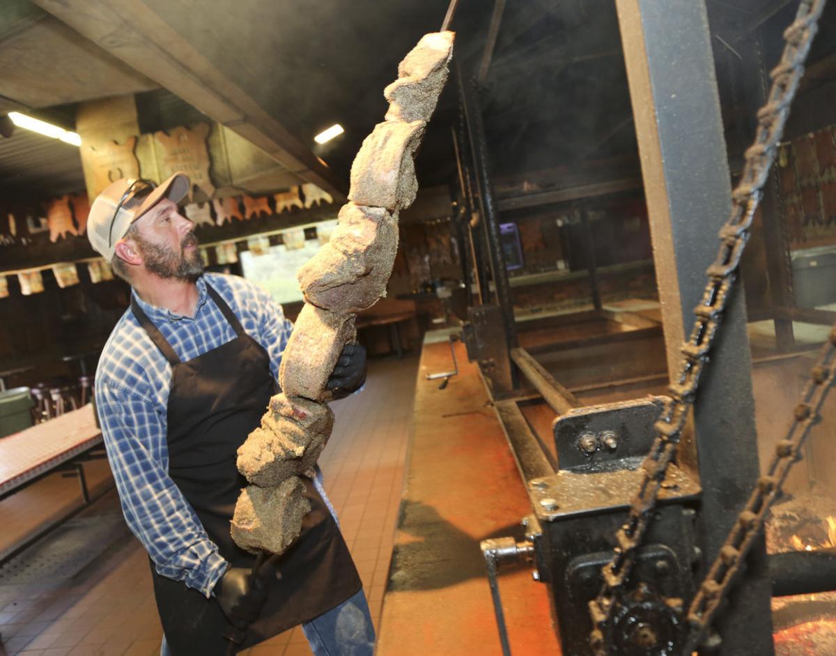 Preparing tri-tip on a metal rod for cooking over an open flame.