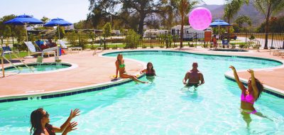Men and women throwing an inflatable ball around in pool
