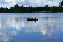 Man on boat fishing in lake