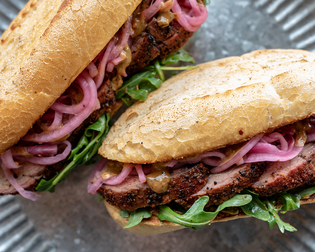 A pair of grilled steak sandwiches ready to serve.