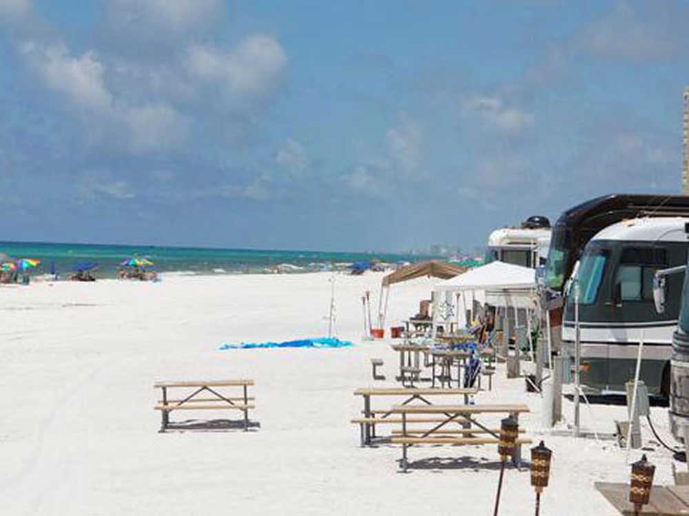 A row of RVs face the white-sand beach and turquoise waters of the Gulf of Mexico in Destin.