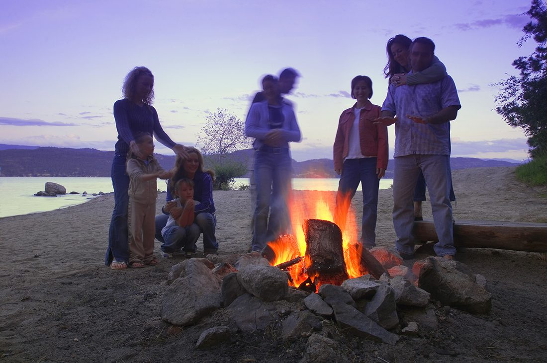 A family gathers around a campfire.