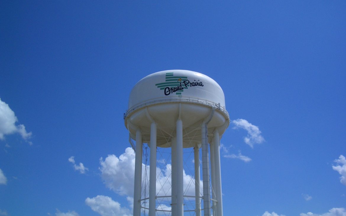 Large white water tower against blue sky