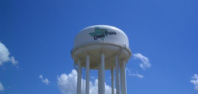 Large white water tower against blue sky