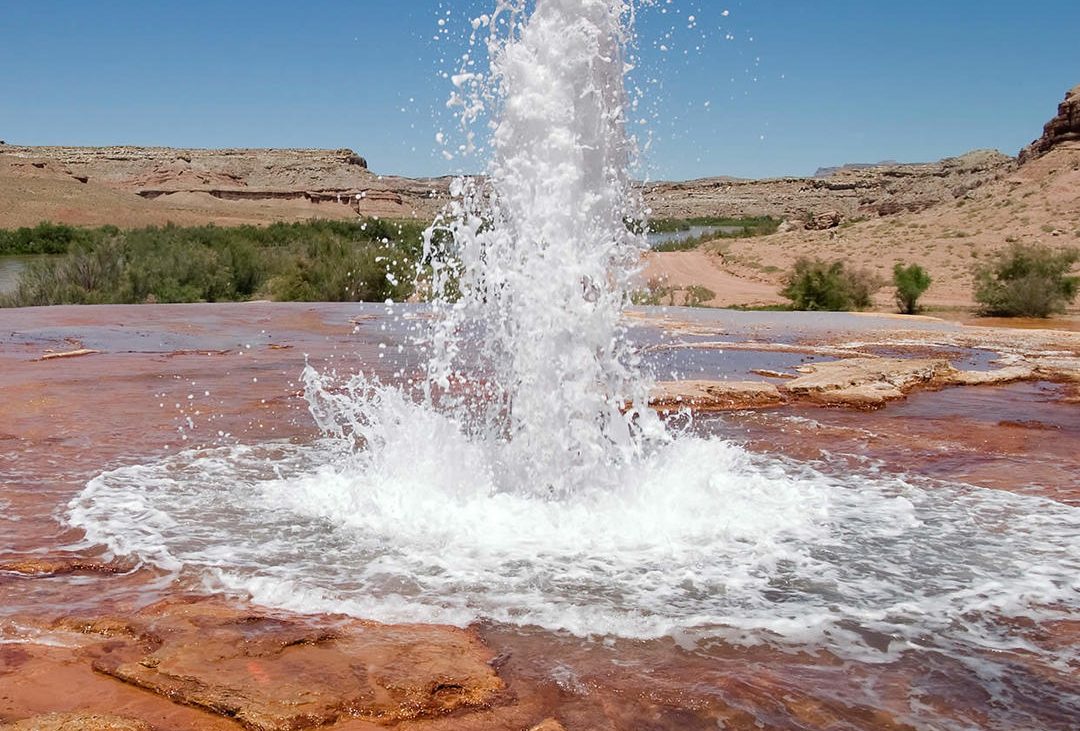 Water erupting from red rock